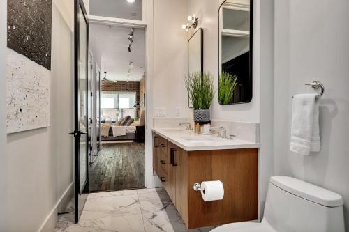 a bathroom with a toilet and a sink and a mirror at Loft Style Spacious Lux Apt, Sleeps 6 in Atlanta