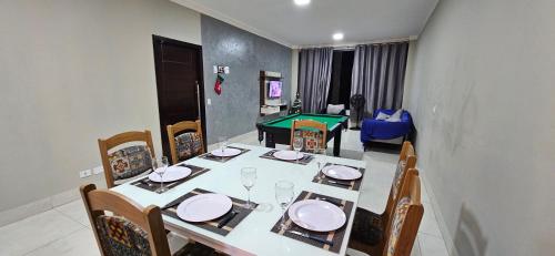 uma mesa de jantar com cadeiras e mesa em Casa do Sonho, Piscina, Sinuca, Churrasqueira em Maringá