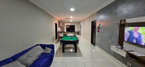 Televisyen dan/atau pusat hiburan di Casa espaçosa, mesa de sinuca e piscina aquecida!