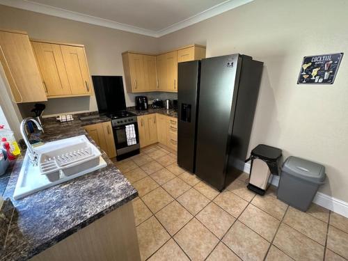 唐克斯特的住宿－Modern 3BD Home Doncaster South Yorkshire，厨房配有黑色冰箱和垃圾桶