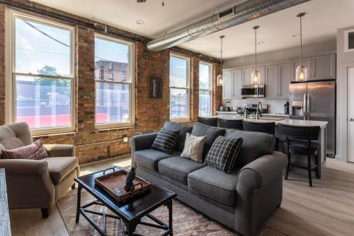 een woonkamer met een bank en een keuken bij Rhinegeist next door - Free streetcar - Walk OTR in Cincinnati