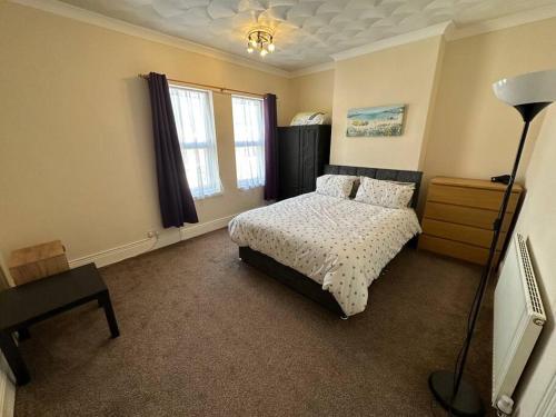 a bedroom with a bed and a desk and a lamp at Modern 3BD Home Doncaster South Yorkshire in Doncaster