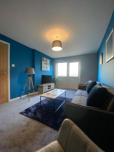 a living room with a couch and a table at Modern Home with Free Parking Sleeps 6 in Leeds