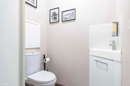 a white bathroom with a toilet and a sink at Cosy place for 4 - Fairytale Factory in Bussy-Saint-Georges