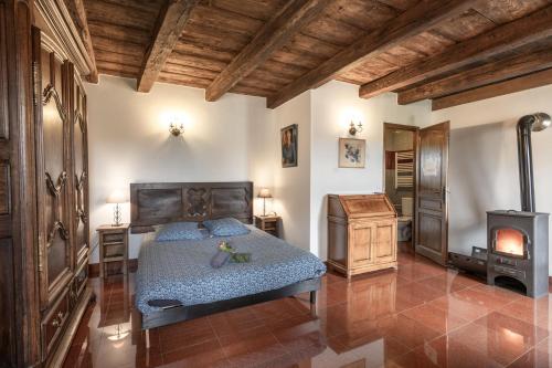 - une chambre avec un lit et un poêle à bois dans l'établissement Franche comté limite vosges Spa, à Mailleroncourt-Saint-Pancras