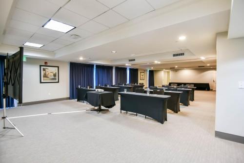 a conference room with tables and chairs and a screen at Shutters Hotel in Elko