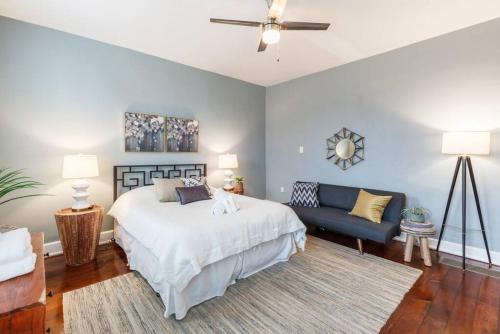 een slaapkamer met een wit bed en een blauwe bank bij Stylish Flat in Walkable Downtown w Parking in Cincinnati