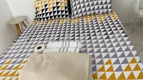 uma cama com almofadas coloridas e toalhas em Apartamento aconchegante próx ao Centro - 1 quarto em Vitória da Conquista