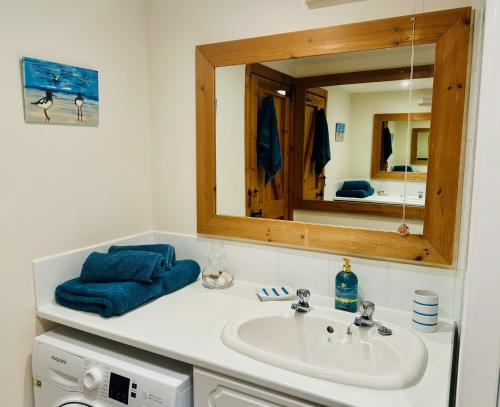 a bathroom with a sink and a mirror at Tigh Mairi at Mary's Thatched Cottages in Elgol