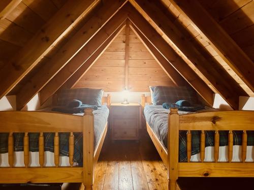 a room with two beds in a attic at Tigh Mairi at Mary's Thatched Cottages in Elgol