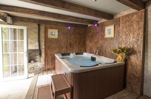 une grande baignoire dans une pièce avec une fenêtre dans l'établissement Franche comté limite vosges Spa, à Mailleroncourt-Saint-Pancras