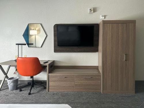 a room with a tv and a desk and a chair at Holiday Inn Express Hotel & Suites Ennis by IHG in Ennis