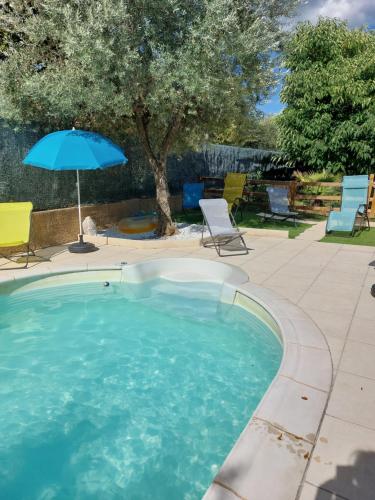 - une piscine avec un parasol, des chaises et une table dans l'établissement gites pleine nature - la Tournette -, à Saint-Martin-dʼArdèche