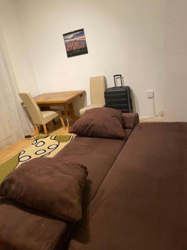 a room with two beds and a table and a desk at Big room for 2 pers, 9 min to trade fare, FREE parking in Frankfurt/Main