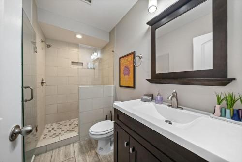 a bathroom with a sink and a toilet and a mirror at Classy 2BR Condo Near City Centre - OTR, UC, Zoo in Cincinnati