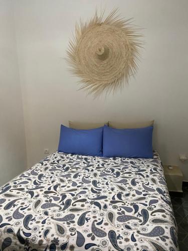 a bedroom with a bed with blue pillows and a decoration at Appartement 3 Riad Dar Samar in Tamraght Ouzdar