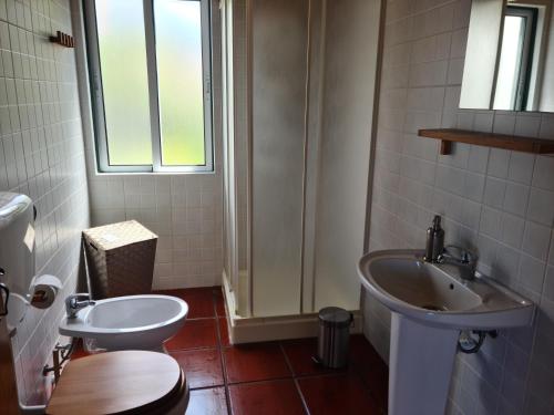 a bathroom with a toilet and a sink at StoneWood Lodge AL in São Vicente Ferreira