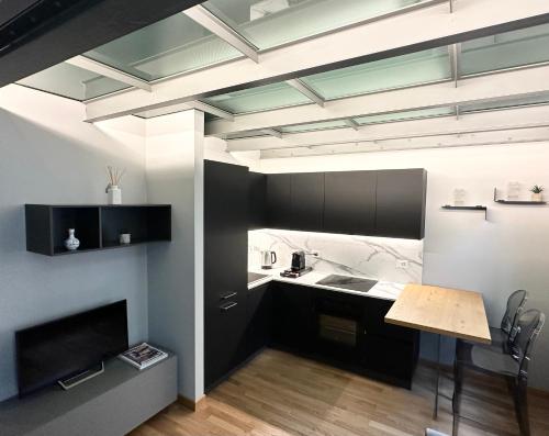- une cuisine avec des placards noirs, un évier et une table dans l'établissement Jacuzzi Luxury Apartment in the Town Centre, à Turin