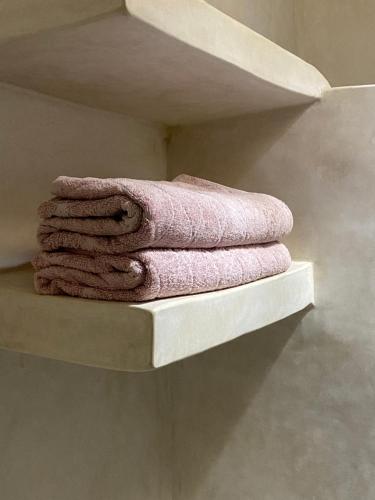 a pile of towels sitting on a shelf at Appartement 3 Riad Dar Samar in Tamraght Ouzdar