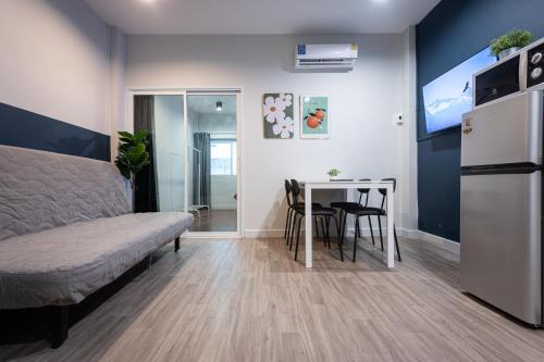 a room with a bed and a table and a refrigerator at A4 Cosy Twin large beds - Silom in Bangkok