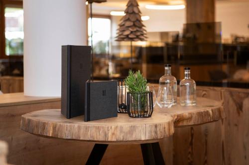 a wooden table with bottles and a plant on it at Hotel Brugger in Fulpmes