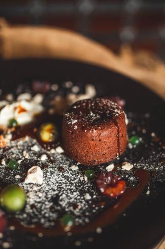 a chocolate dessert on a black plate on a table at Hotel Rycerski in Czeladź