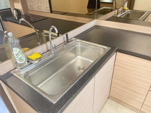 a stainless steel kitchen sink in a kitchen at Rex-apartment 3room near new Kpj Saradise Bdc in Kuching