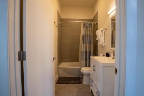 ein Bad mit einer Dusche, einem WC und einem Waschbecken in der Unterkunft Inner Harbor's Best Furnished Luxury Apartments apts in Baltimore