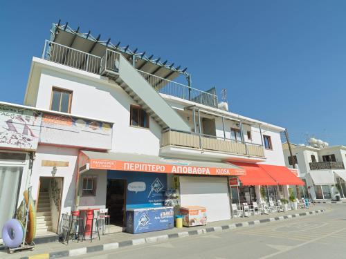a white building with a balcony on top of it at Zima Two Seaside in Zygi