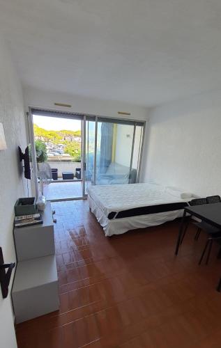 une chambre avec un lit et une grande fenêtre dans l'établissement Studio 137 Port Camargue, Piscine, Climatisation, 4 personnes, au Grau-du-Roi