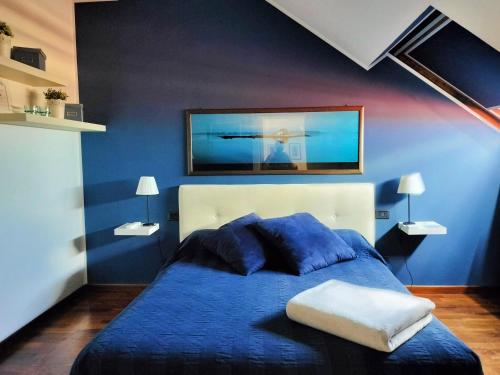 1 dormitorio azul con 1 cama con pared azul en Mansarda DaSy en Ancona