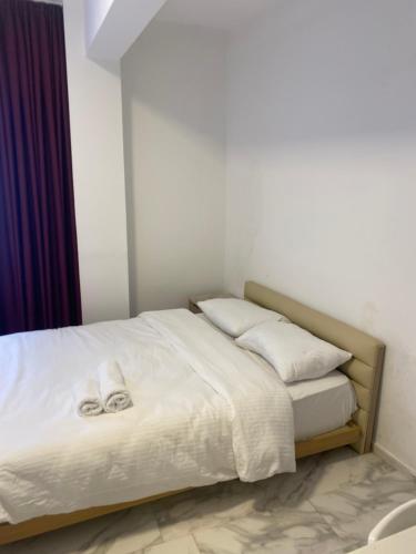 łóżko z białą pościelą i poduszkami w pokoju w obiekcie yenikapı hotel w Stambule