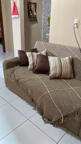 a couch sitting on a tiled floor with pillows on it at Aconchego MCC in João Pessoa