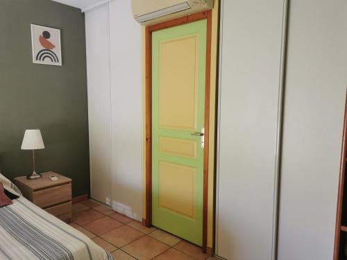 a bedroom with a green door and a bed at Chambre spacieuse avec bureau et balcon in Millas