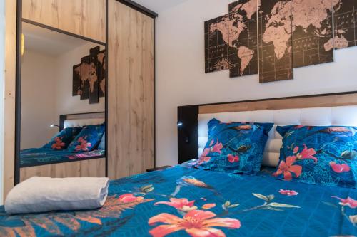 1 dormitorio con cama azul y espejo en ARMONA, en Brides-les-Bains