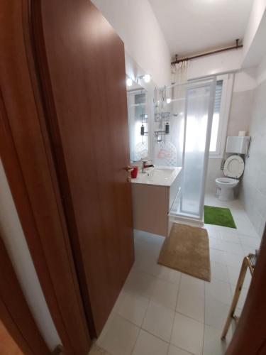 uma casa de banho com um WC, um lavatório e um espelho. em Appartamento Venezia em Marghera