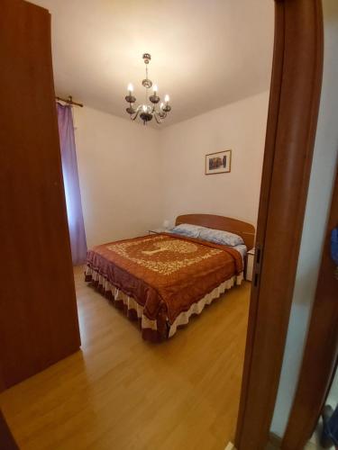 a bedroom with a bed and a chandelier at Appartamento Venezia in Marghera