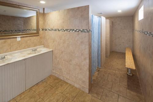 a bathroom with a shower and a sink and a mirror at Ocean Grove RV Resort St Augustine in Saint Augustine