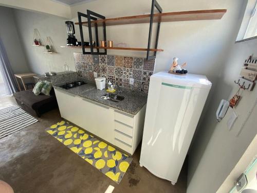 a small kitchen with a counter and a refrigerator at Lofts Umuarama Residence in Uberlândia