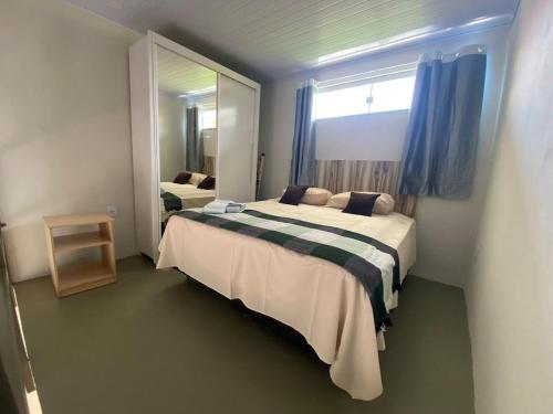 Lofts Umuarama Residence في أبرلانديا: غرفة نوم بسريرين ومرآة كبيرة