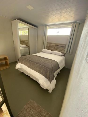 a bedroom with a large bed and a window at Lofts Umuarama Residence in Uberlândia