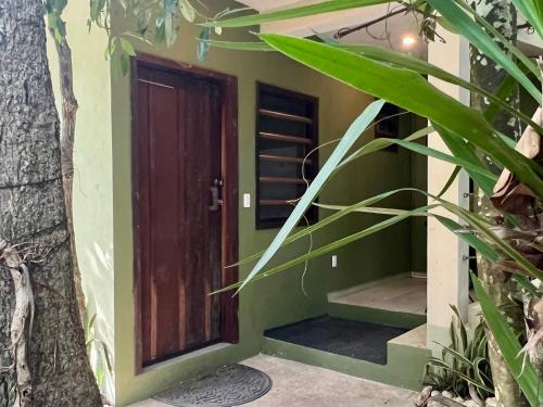 a house with green walls and a wooden door at Hokhmah Heart Hotel in Puerto Morelos