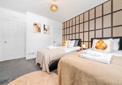 a bedroom with two beds and a large wall at Uddingston Apartment by Klass Living in Uddingston