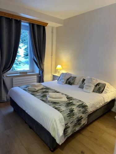 クソンリュプト・ロンジュメールにあるMaison d'hôtes La Devinière - Spa accessible toute l'annéeのベッドルーム1室(大型ベッド1台、タオル付)