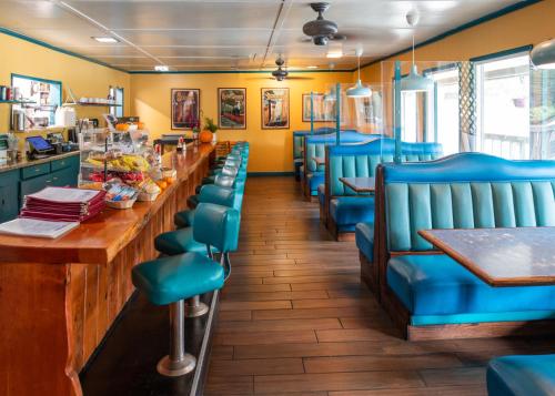 a restaurant with blue chairs and a long bar at Buck Meadows Lodge in Groveland