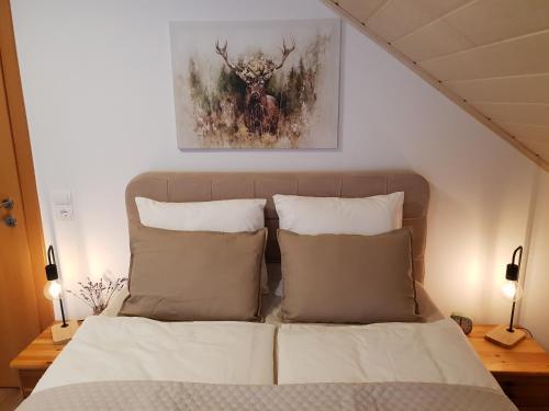 a bedroom with a bed with pillows and a painting at Alpenloft Theresia in Ferlach