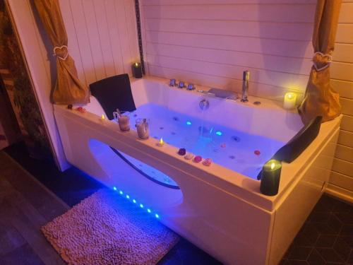 特雷布的住宿－Le temps suspendu，浴室配有带灯的浴缸。