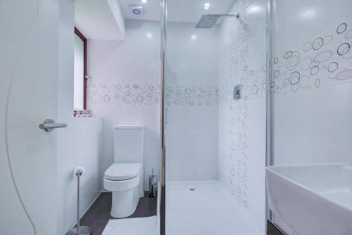 a white bathroom with a toilet and a shower at Open Mind Property - City Centre & Free Parking for Unlimited Vehicles in Fareham