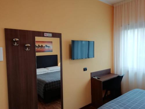 Habitación con 1 dormitorio con 1 cama y TV. en House Volusia, en La Giustiniana