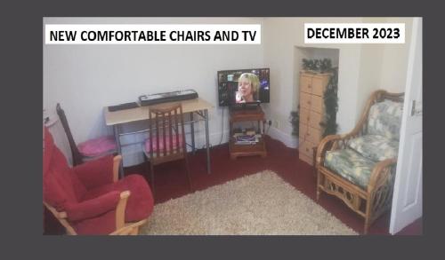 sala de estar con 2 sillas y TV en Central Location shops & beach en Milford on Sea